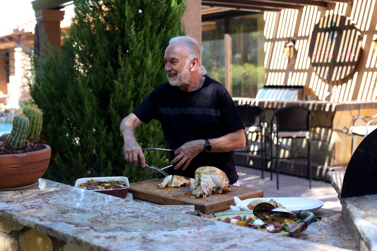 Hubert Keller cuts a rotisserie chicken in his backyard kitchen in Las Vegas. (Rachel Aston/Las ...