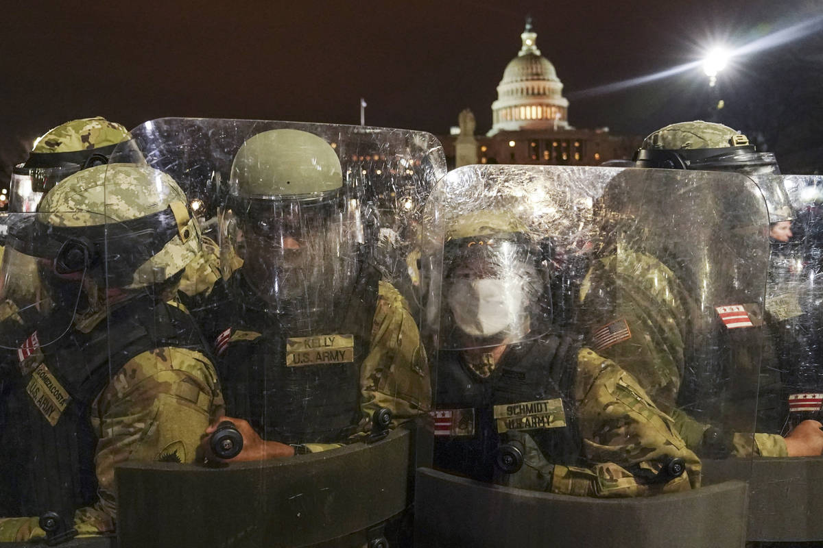 DC National Guard stand outside the Capitol, Wednesday night, Jan. 6, 2021, after a day of riot ...