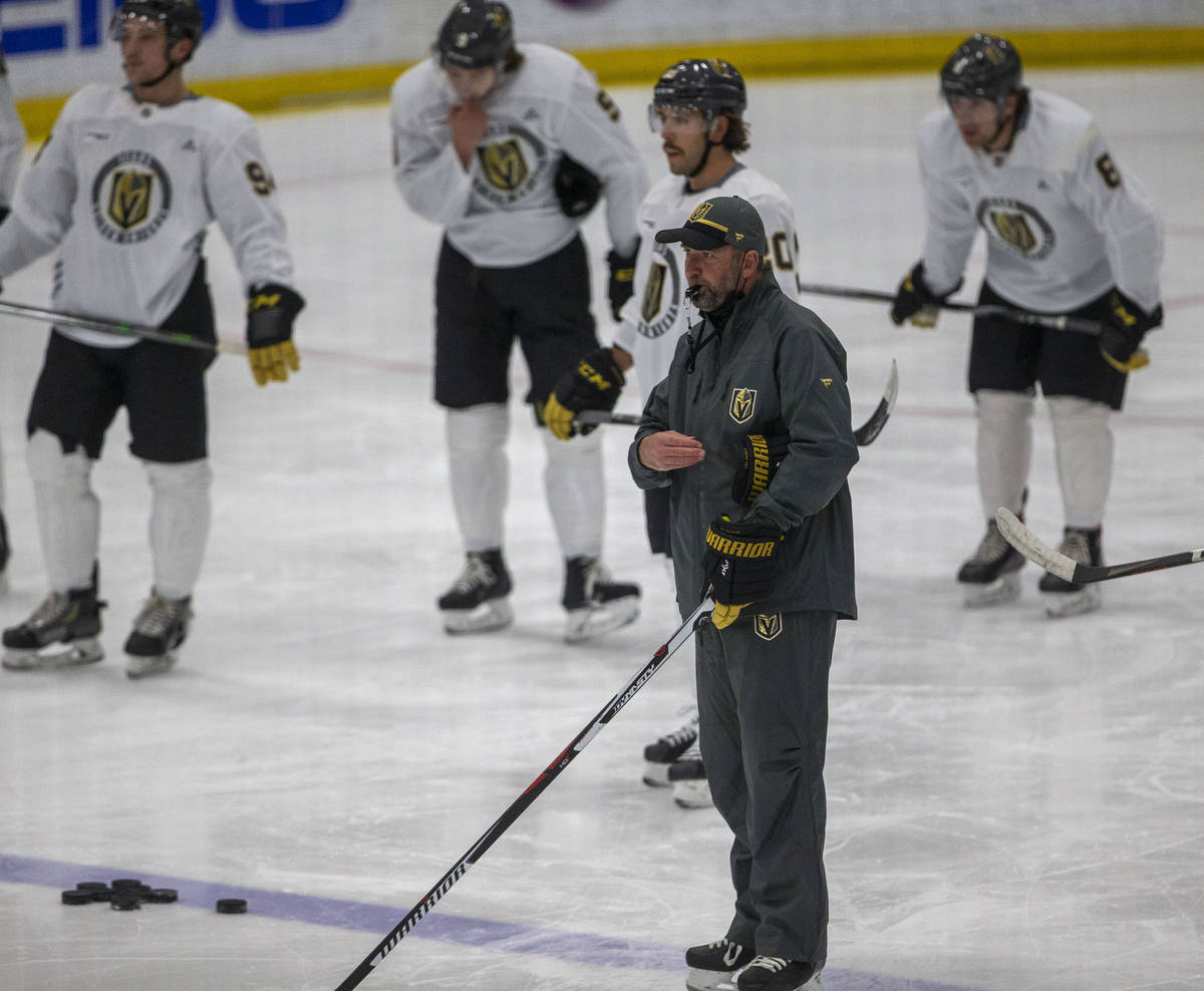 Golden Knights head coach Pete DeBoer blows his whistle as players look on during training camp ...