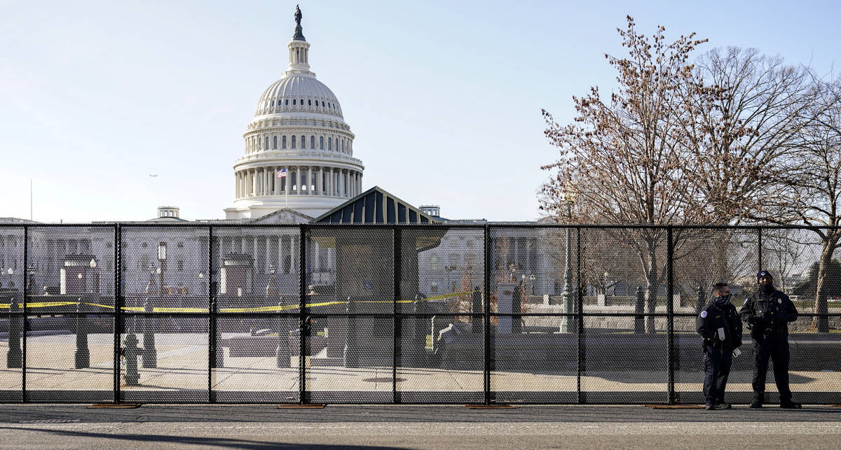 Capitol police officers stand outside of fencing that was installed around the exterior of the ...