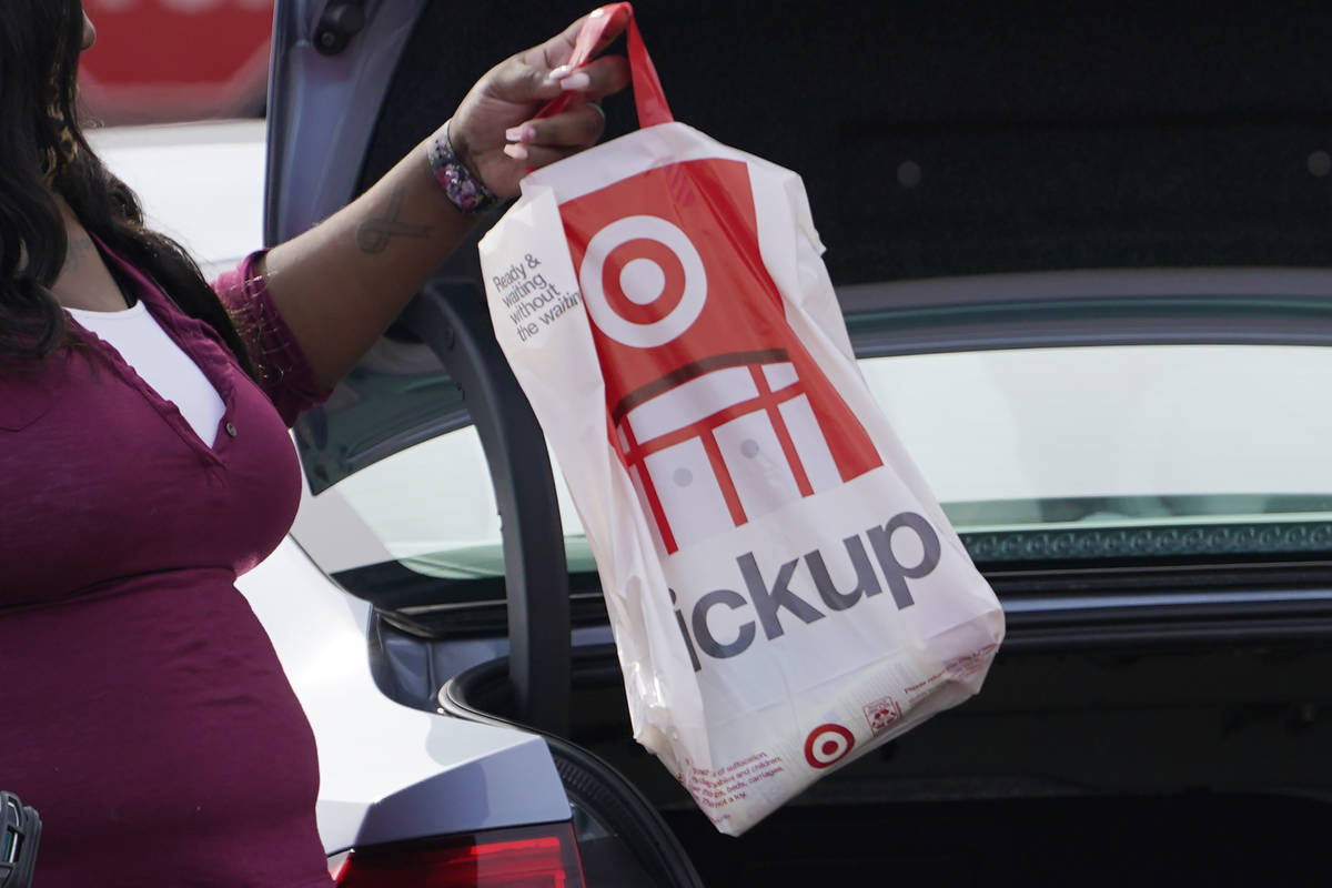A Target employee places a curbside pickup purchase into the trunk of a customer in Jackson, Mi ...