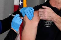 Mesa Fire Department Capt. Jeff Stieber, right, receives the Pfizer-BioNTech vaccine for COVID- ...