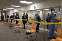 FILE - In this Dec. 24, 2020, file photo, healthcare workers wait in line to receive the Pfizer ...