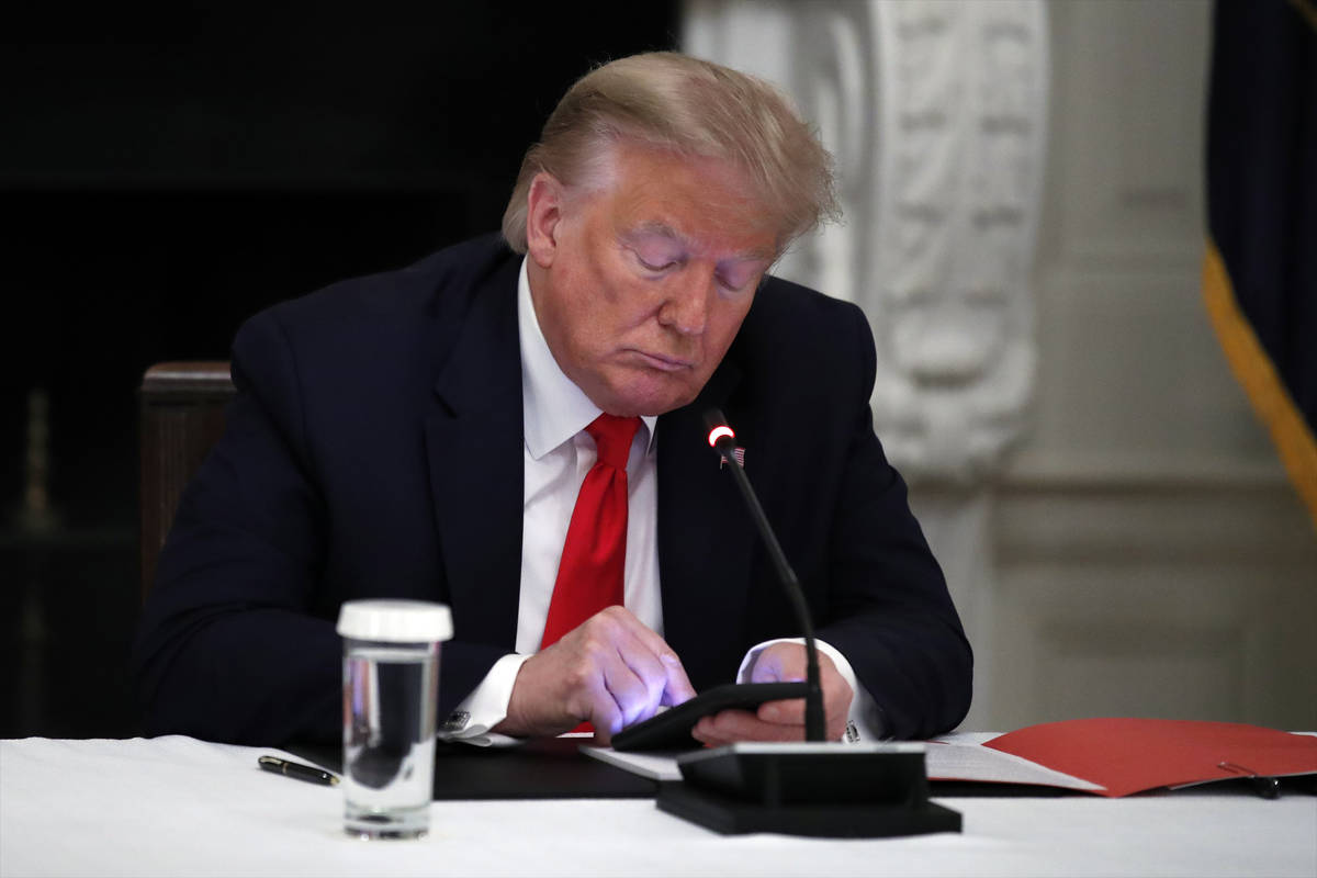 FILE - In this Thursday, June 18, 2020 file photo, President Donald Trump looks at his phone du ...