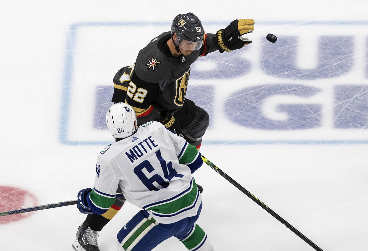 Vancouver Canucks' Tyler Motte (64) and Vegas Golden Knights' Nick Holden (22) battle for the p ...