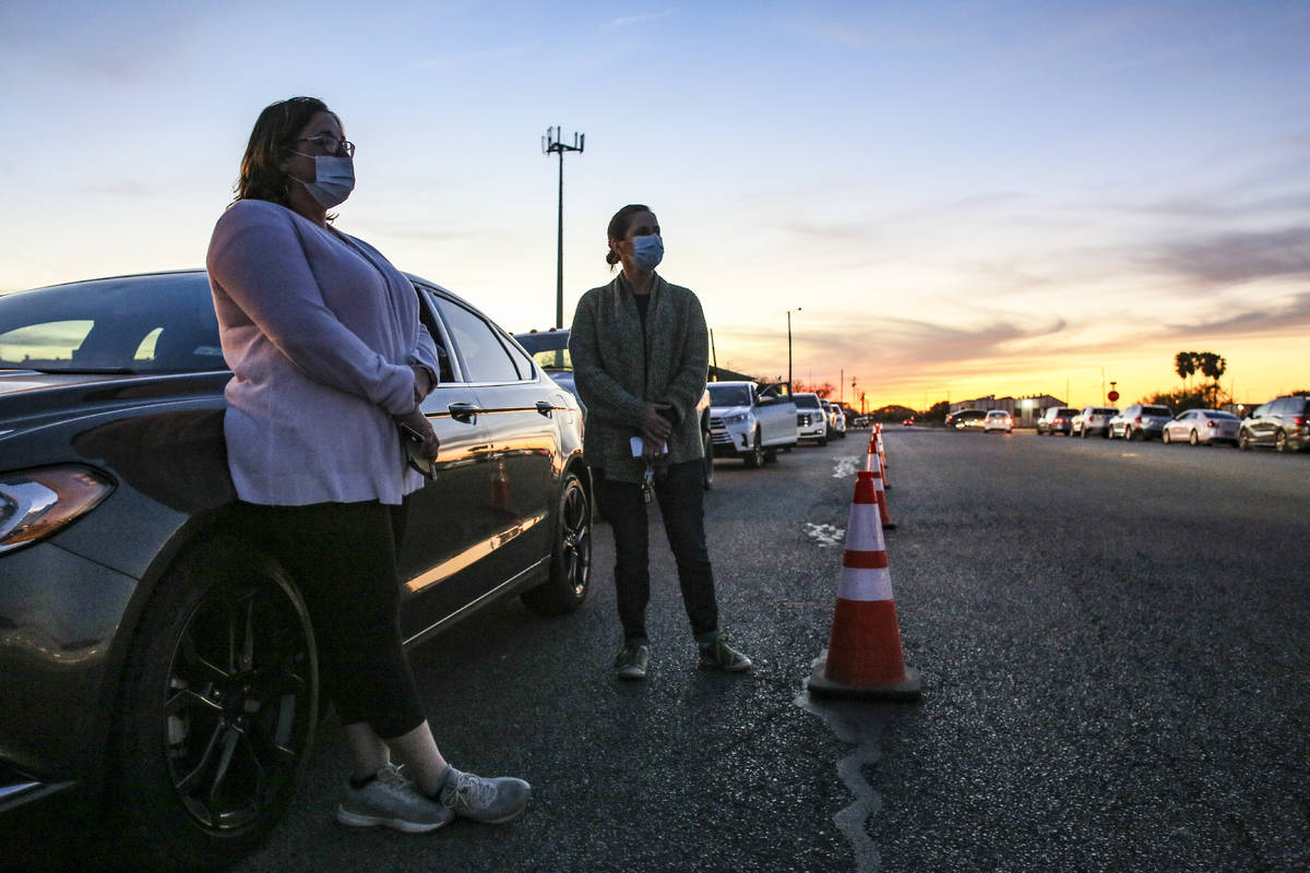 In a Thursday, Jan. 7, 2021, photo, Cindy Rubiano and Trolena Loya stand outside their car as t ...