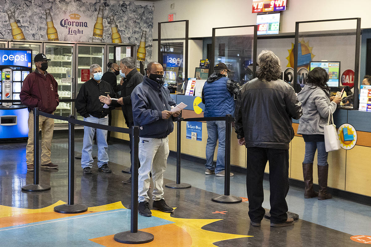 People line up inside of the Prime Valley Lotto Store as they wait to buy the Mega Million and ...