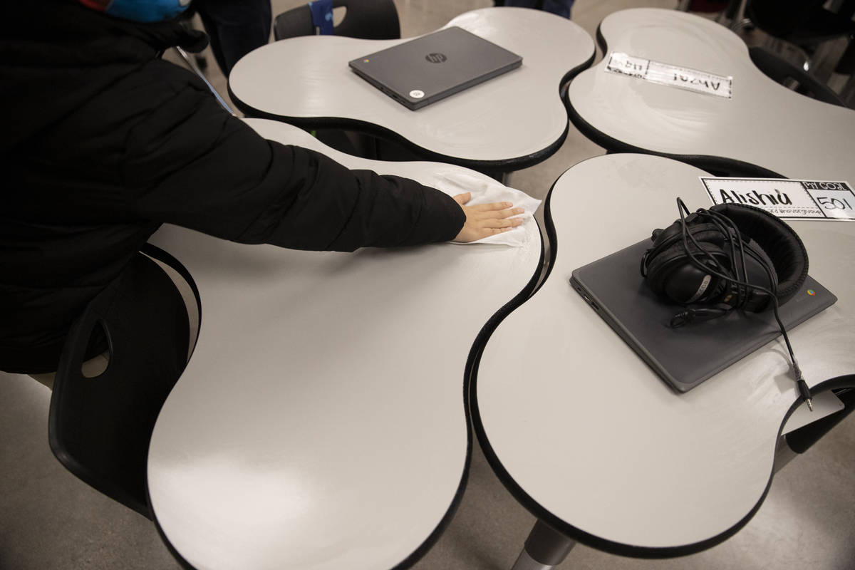 A student wipes down his desk at the end of his class at Mater Academy East Campus in Las Vegas ...