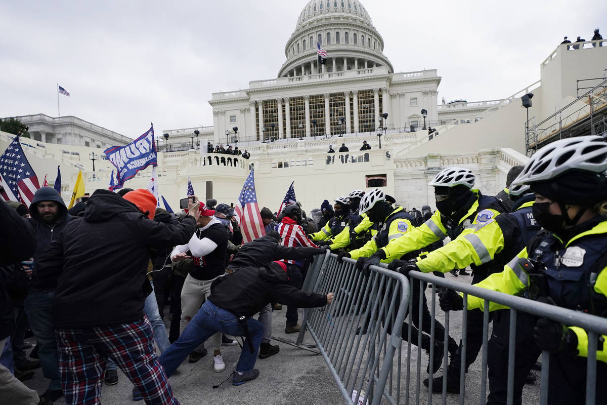 FILE - In this Jan. 6, 2021, file photo, Trump supporters try to break through a police barrier ...