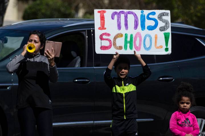 Las Vegas residents wave to teachers and staff from O’Roarke Elementary School who organ ...