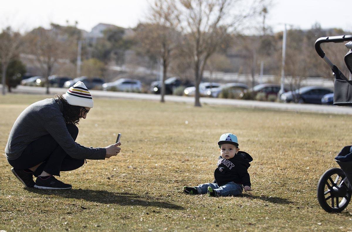 Lindsey Daub tries to get her 13-month-old son's, Luke, attention as she takes a picture of him ...