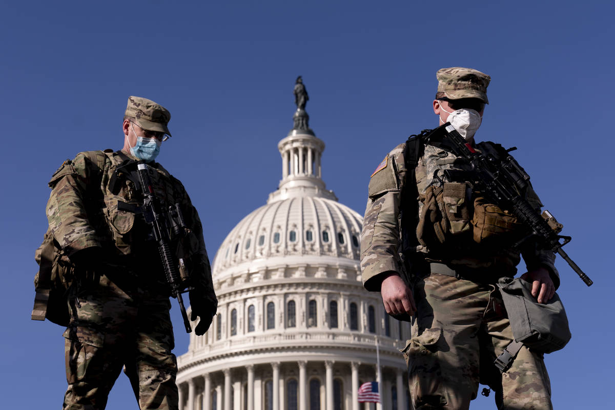 Members of the National Guard walk past the Dome of the Capitol Building on Capitol Hill in Was ...