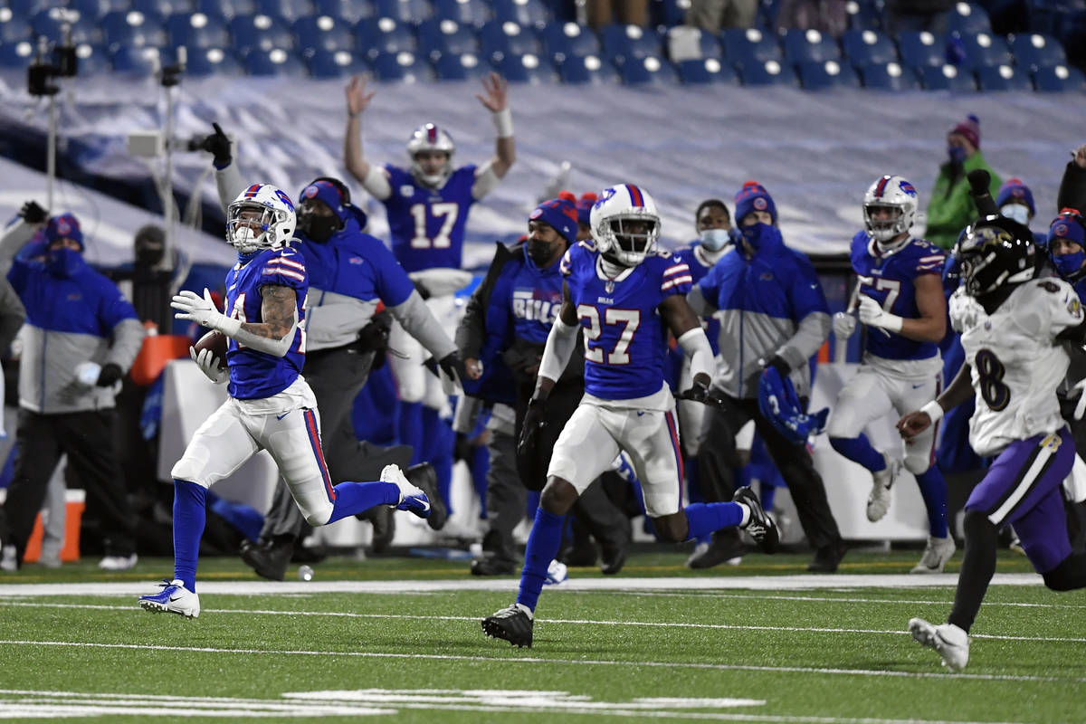Buffalo Bills cornerback Taron Johnson, left, runs away from Baltimore Ravens quarterback Lamar ...