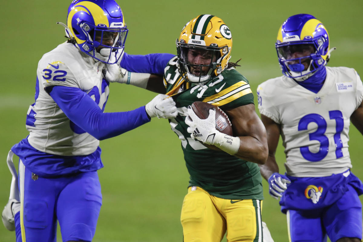 Green Bay Packers' Aaron Jones (33) is chased down by Los Angeles Rams' Jordan Fuller (32) and ...