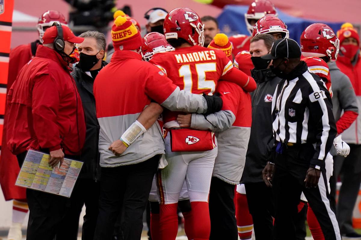 Kansas City Chiefs quarterback Patrick Mahomes (15) is helped off the field after getting injur ...