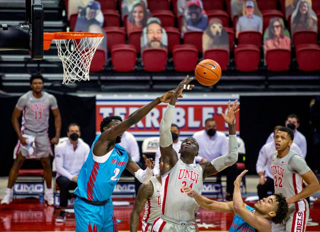 UNLV Rebels forward Cheikh Mbacke Diong (34) deflects a loose ball from New Mexico Lobos forwar ...