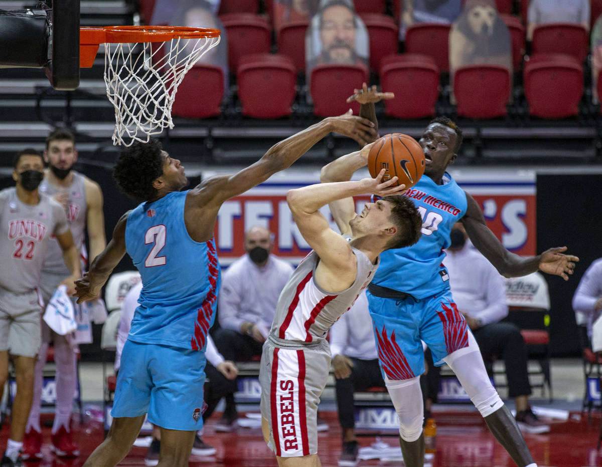 UNLV Rebels guard Caleb Grill (3) leans back to get off a basket between New Mexico Lobos guard ...