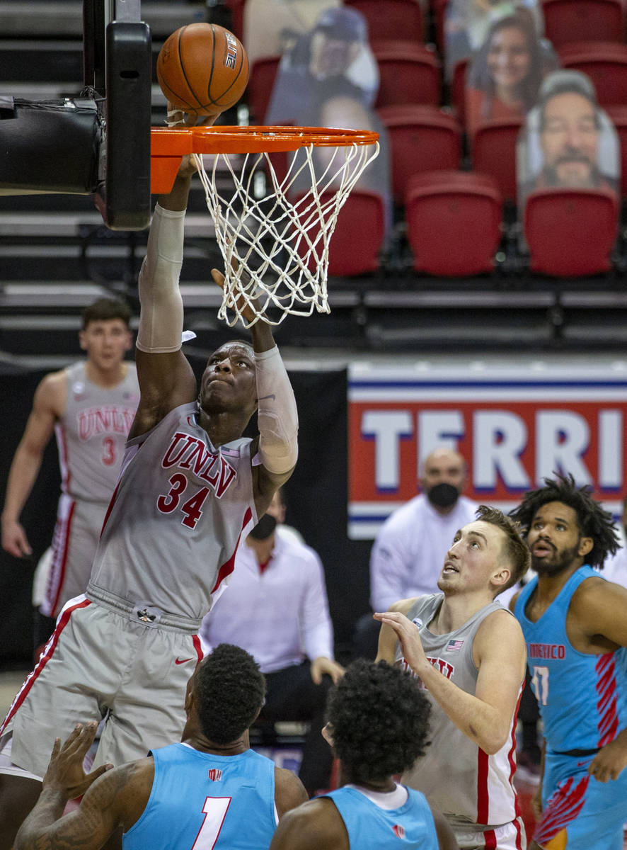 UNLV Rebels forward Cheikh Mbacke Diong (34) readies for a dunk over New Mexico Lobos forward B ...
