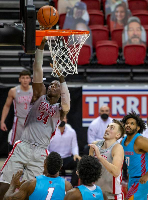 UNLV Rebels forward Cheikh Mbacke Diong (34) readies for a dunk over New Mexico Lobos forward B ...