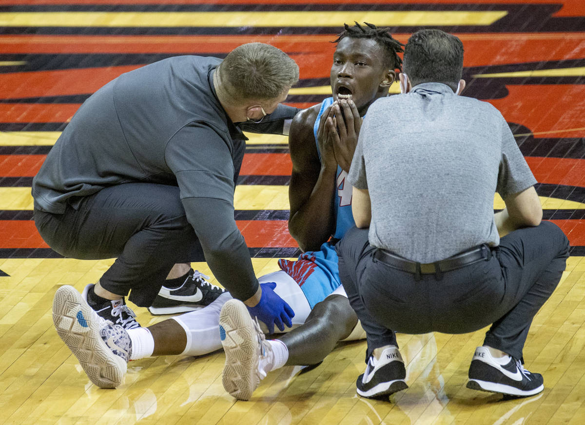 New Mexico Lobos guard Emmanuel Kuac (4) sits dazed on the court after colliding with UNLV Rebe ...