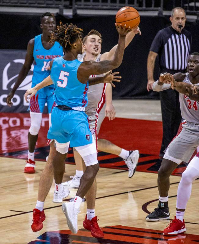 New Mexico Lobos forward Rod Brown (5) has a shot rejected by UNLV Rebels forward Moses Wood (1 ...