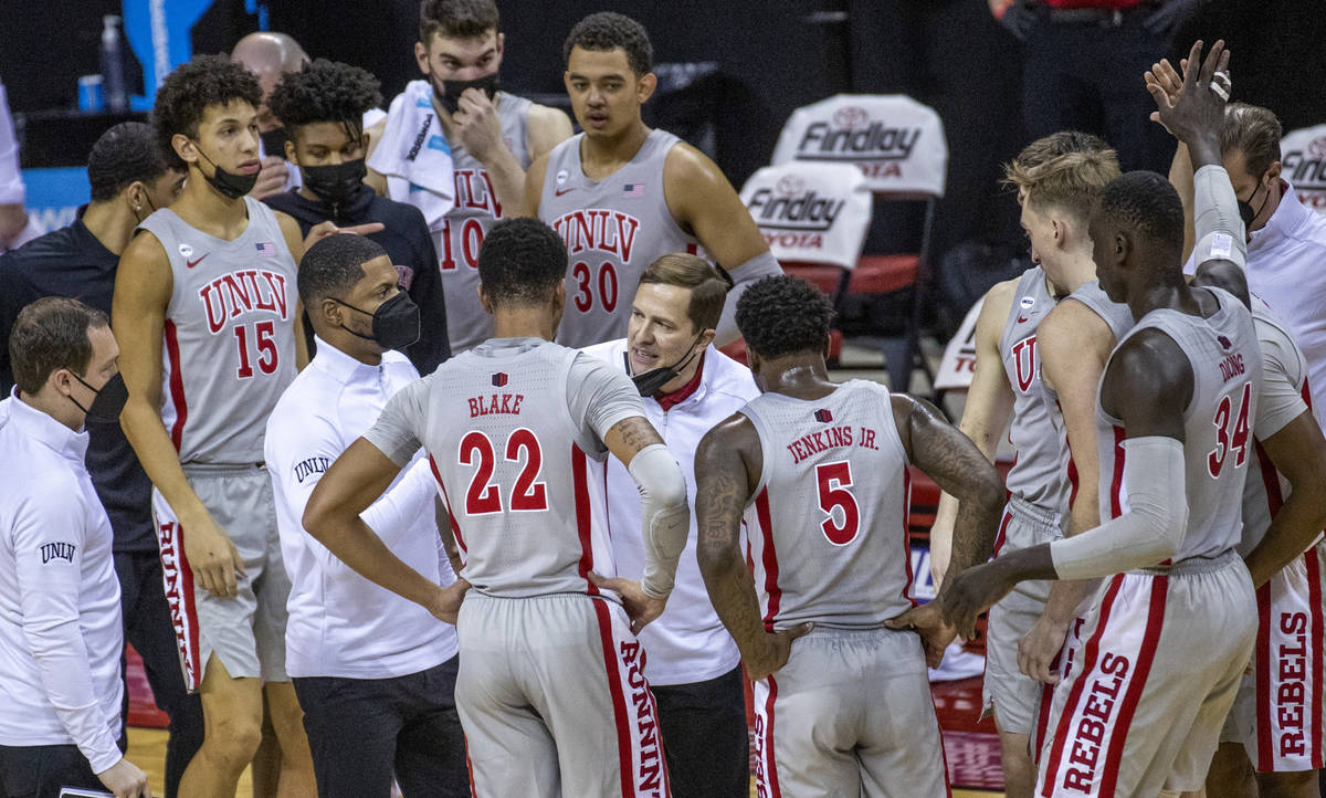 UNLV Rebels head coach T. J. Otzelberger counsels his players during a timeout versus the New M ...