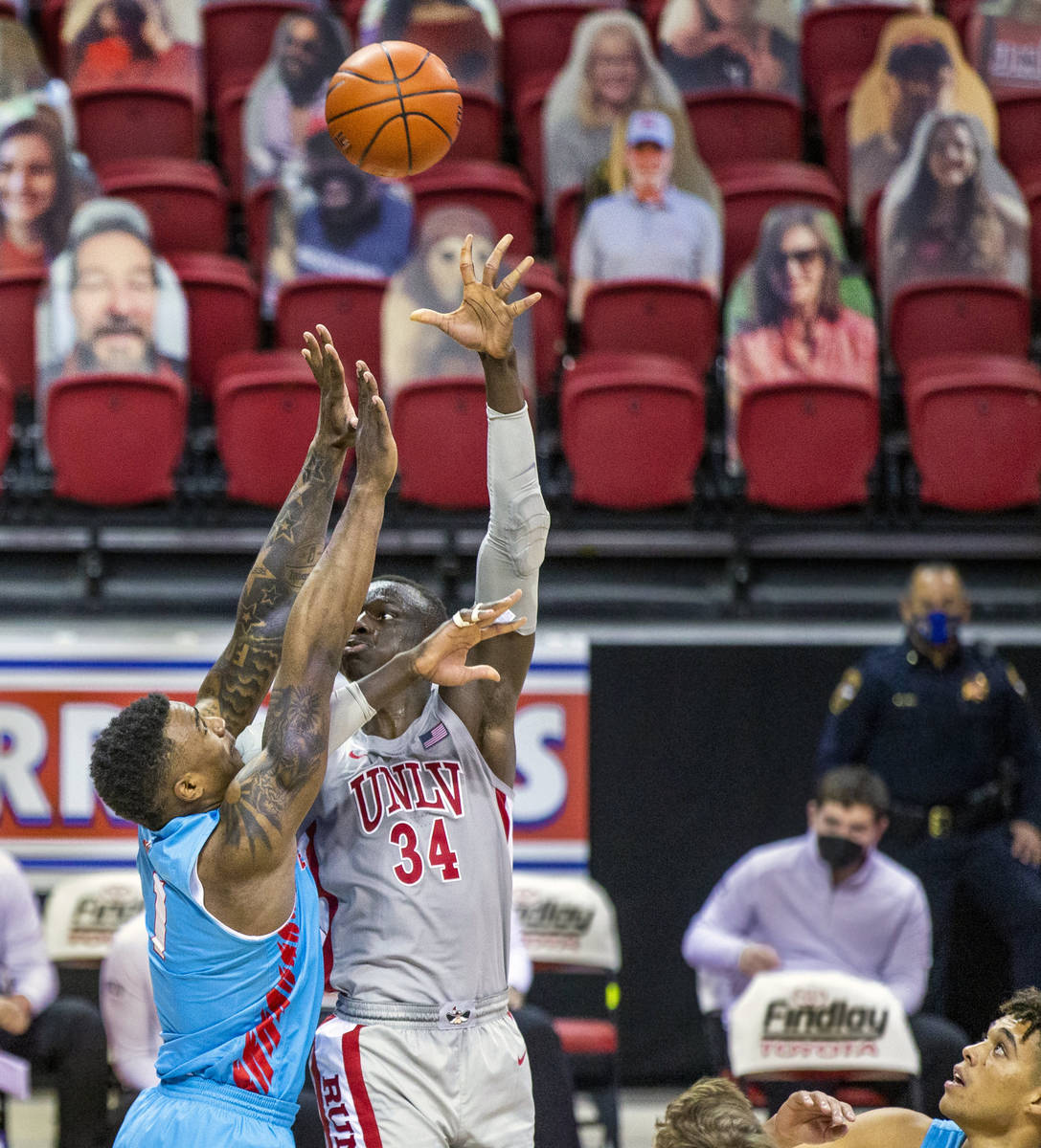 UNLV Rebels forward Cheikh Mbacke Diong (34) gets off a hook shot over New Mexico Lobos forward ...
