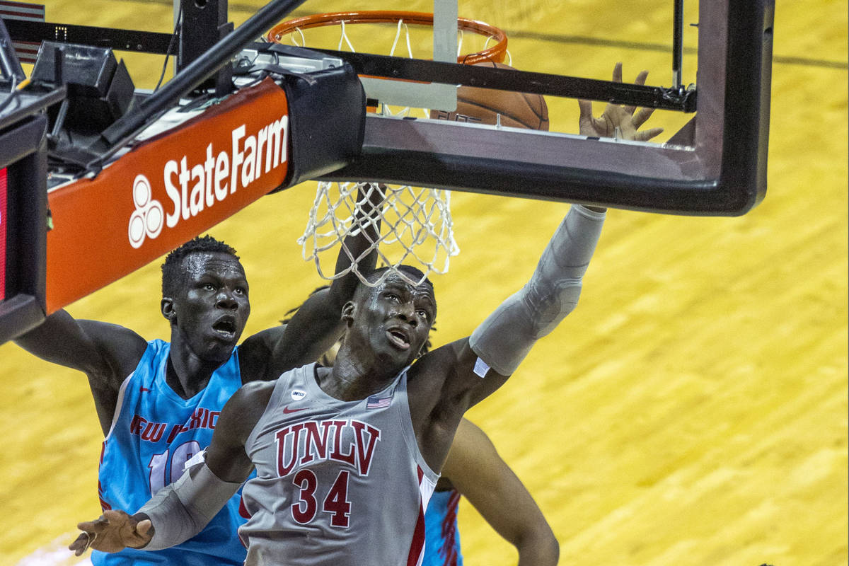 UNLV Rebels forward Cheikh Mbacke Diong (34) battles about the glass with New Mexico Lobos guar ...