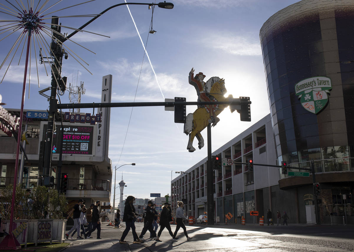 Visitors to downtown cross Fremont Street as temperatures exceeded 70 degrees on Saturday, Jan. ...