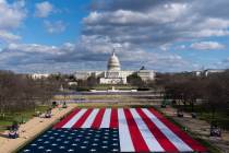 A large American Flag is are placed on the National Mall, with the U.S. Capitol behind, ahead o ...