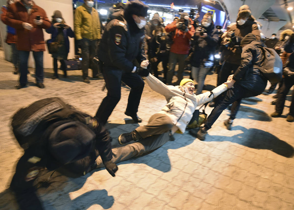 Police officers detain a man at Moscow's Vnukovo airport where Russian opposition leader Alexei ...
