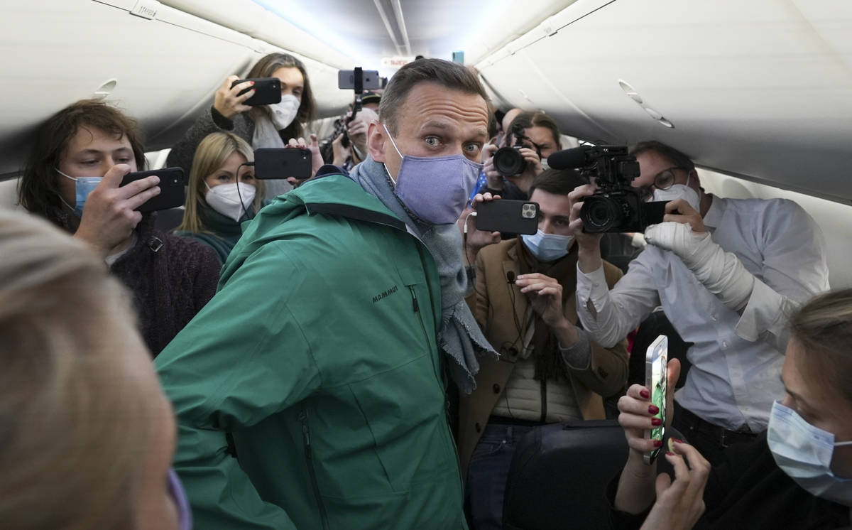 Alexei Navalny is surrounded by journalists inside the plane prior to his flight to Moscow in t ...