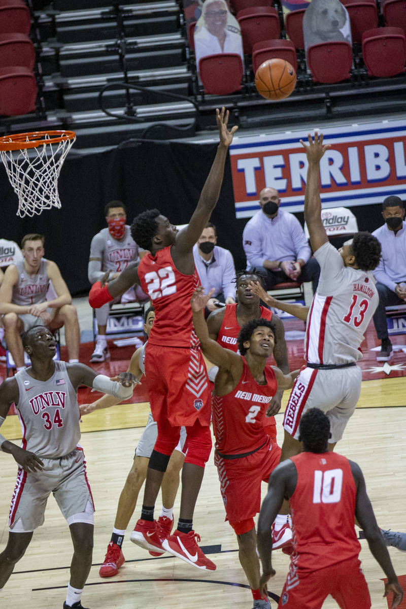 UNLV Rebels guard Bryce Hamilton (13) makes a basket that's contested by New Mexico Lobos forwa ...