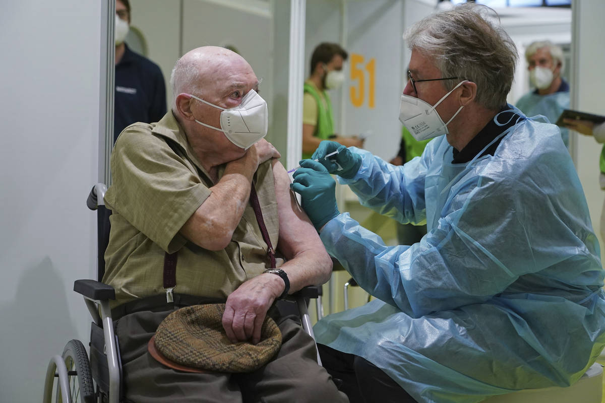 A doctor inoculates Herri Rehfeld, 92, against the new coronavirus with the Pfizer/BioNTech vac ...
