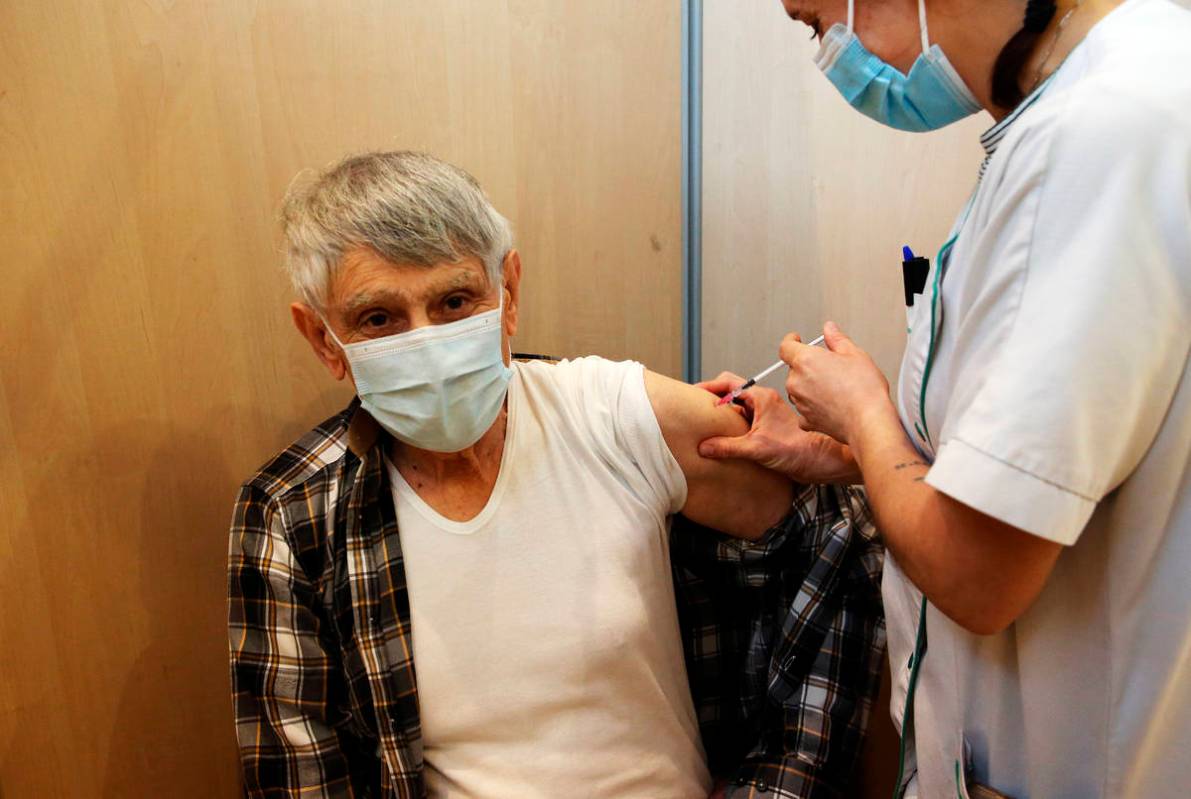 A man receives the Pfizer-BioNTech vaccination against COVID-19 at a vaccination center in Bayo ...