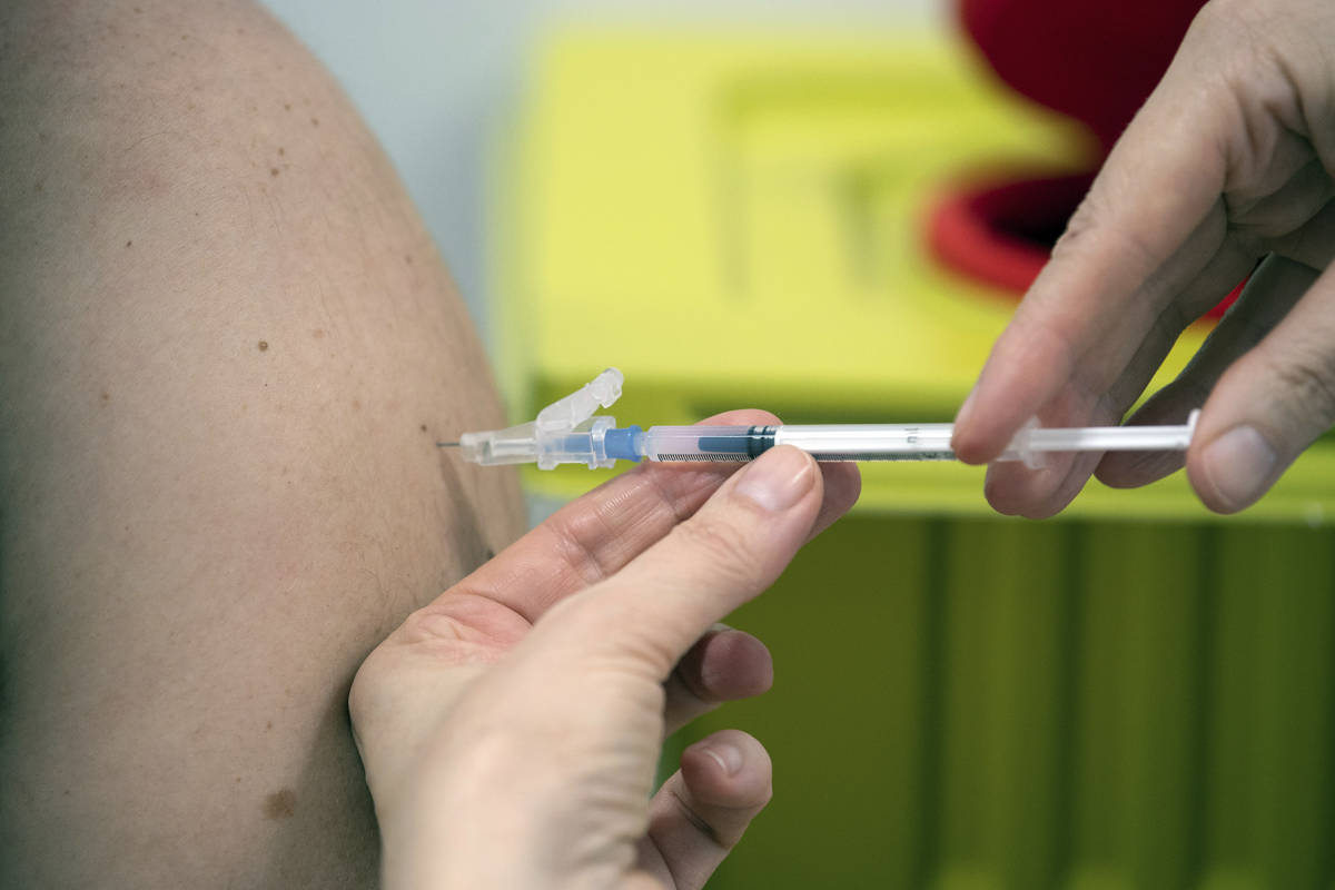 A member of staff at the university hospital injects the Moderna vaccine against COVID-19 into ...