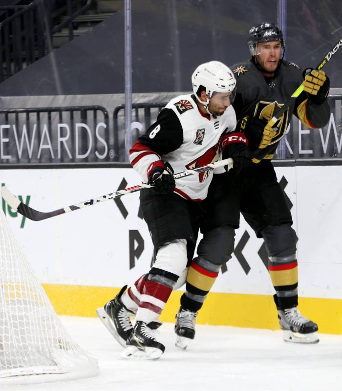 Arizona Coyotes center Nick Schmaltz (8) shoves Golden Knights' defenseman Brayden McNabb (3) d ...