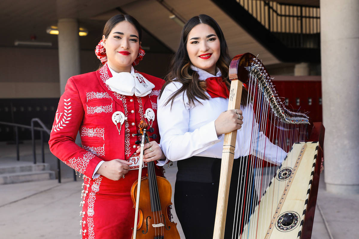 Michelle Madrid, left, who plays the violin, and her twin sister, Rachelle, who plays the harp, ...