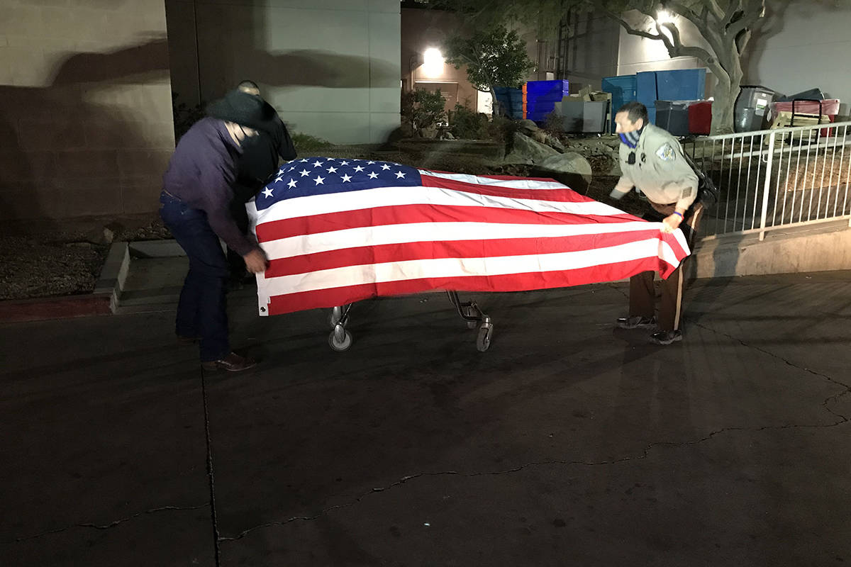 Nye County deputies on Monday, Jan. 18, 2021, drape an American flag over the casket carrying P ...