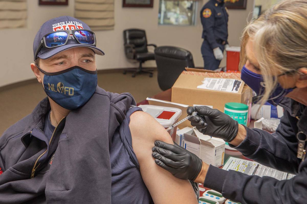 North Las Vegas Fire Department captain David Carraway, 36, left, is administrated a COVID-19 v ...