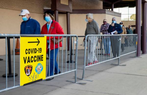 People move along while in line to enter the Cashman Center for COVID-19 vaccinations operated ...