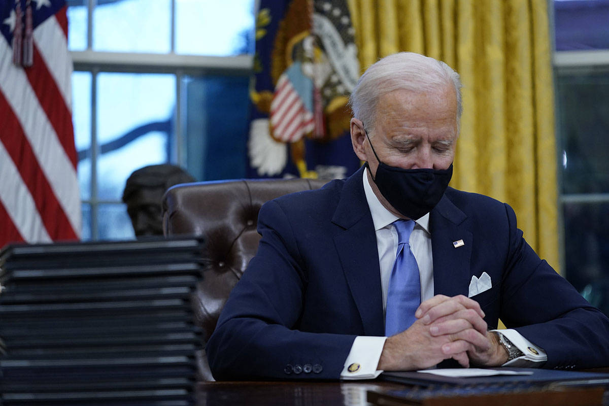 President Joe Biden pauses as he signs his first executive orders in the Oval Office of the Whi ...