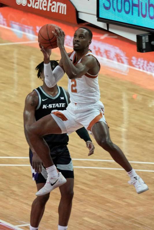 Texas' Matt Coleman III, right, drives past Kansas State's Selton Miguel during the first half ...