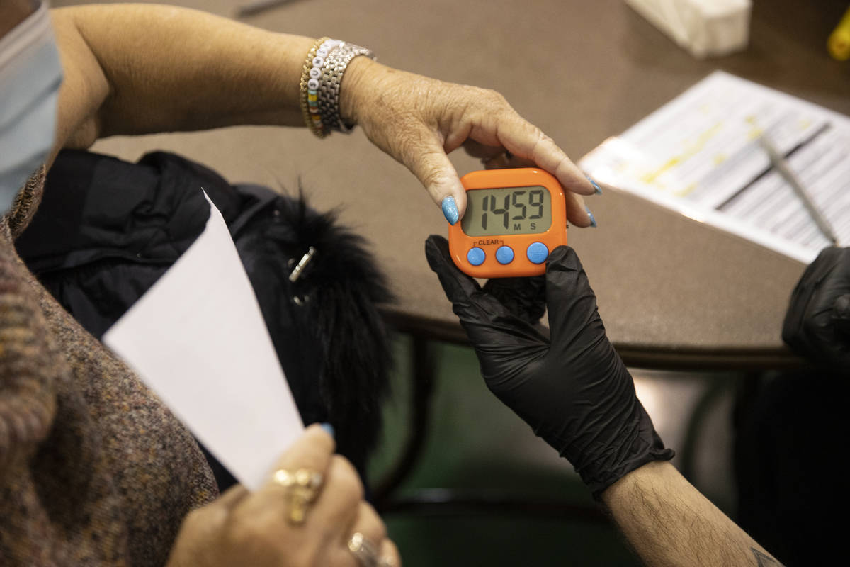 Lynne Lober, 70, receives a 15-minute timer after receiving the COVID-19 vaccine from Nathan Va ...