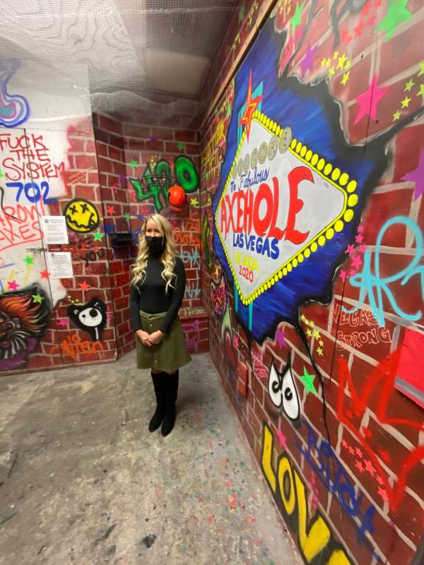 Axe Hole owner London Cochrane is shown in the "Smash Room" in her business at Neonopolis on Th ...
