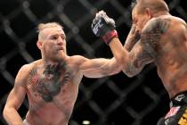 Conor McGregor hits Dustin Poirier with a left during their fight at UFC 178 Saturday, Sept. 27 ...