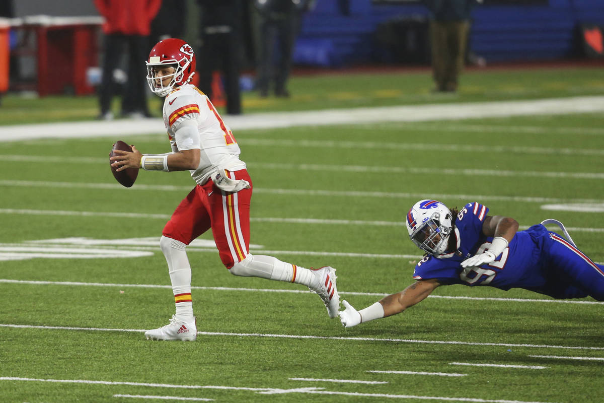 Kansas City Chiefs quarterback Patrick Mahomes, left, outruns Buffalo Bills' Darryl Johnson dur ...
