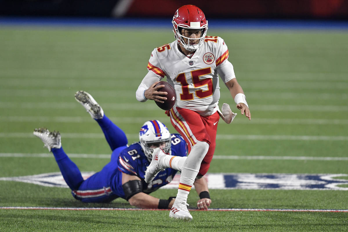 Kansas City Chiefs quarterback Patrick Mahomes (15) evades Buffalo Bills' Justin Zimmer during ...