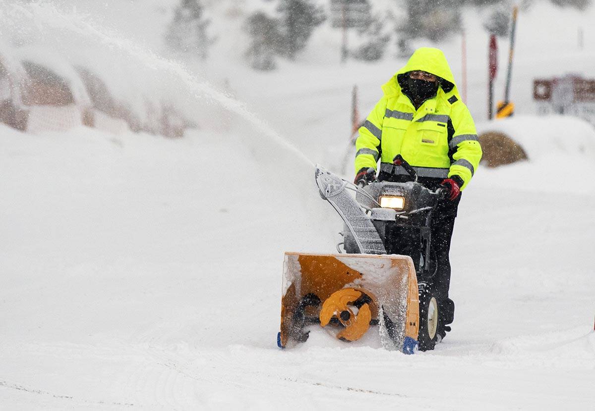 Pedro Diaz clears snow with a snow blower from The Charleston CabinÕs parking lot, on Mond ...