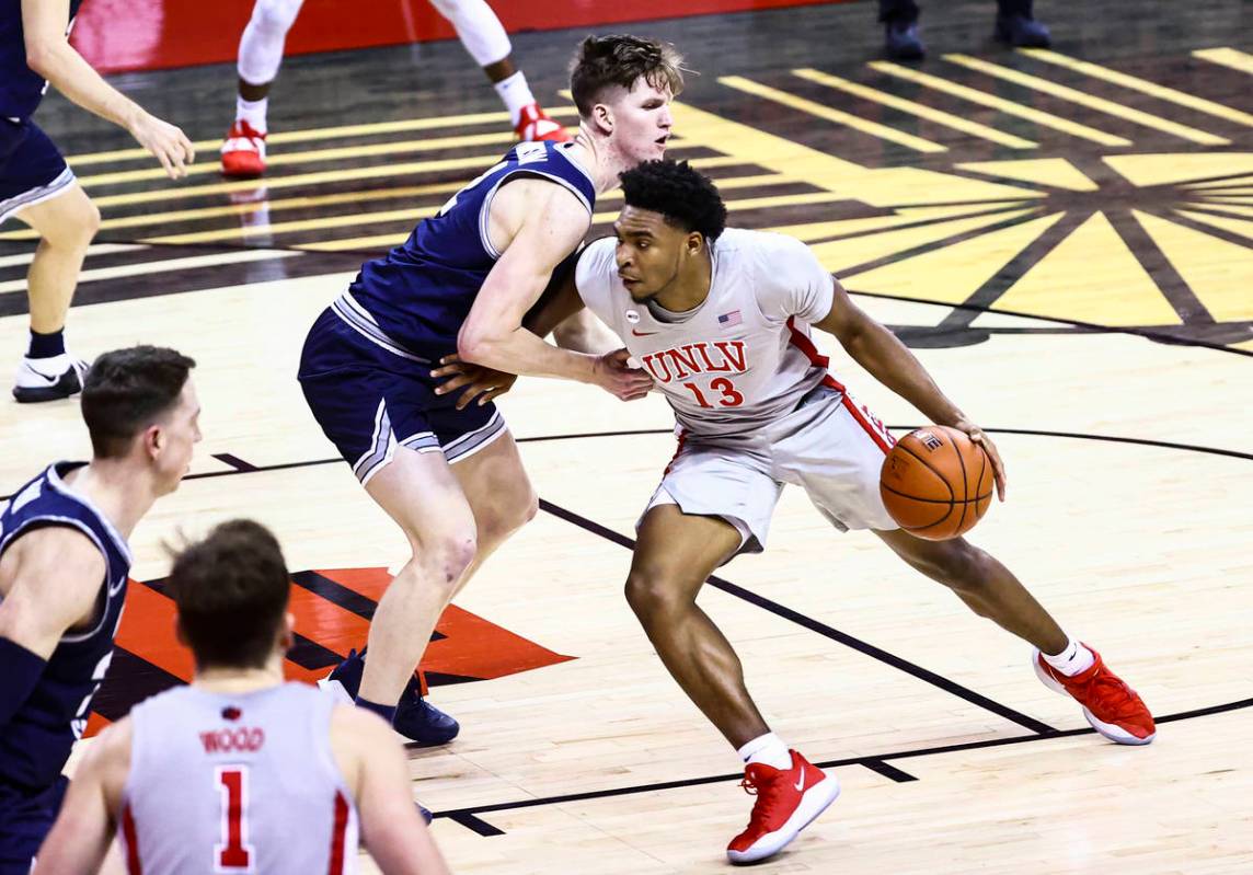 UNLV Rebels guard Bryce Hamilton (13) drives to the basket against Utah State Aggies guard Sean ...